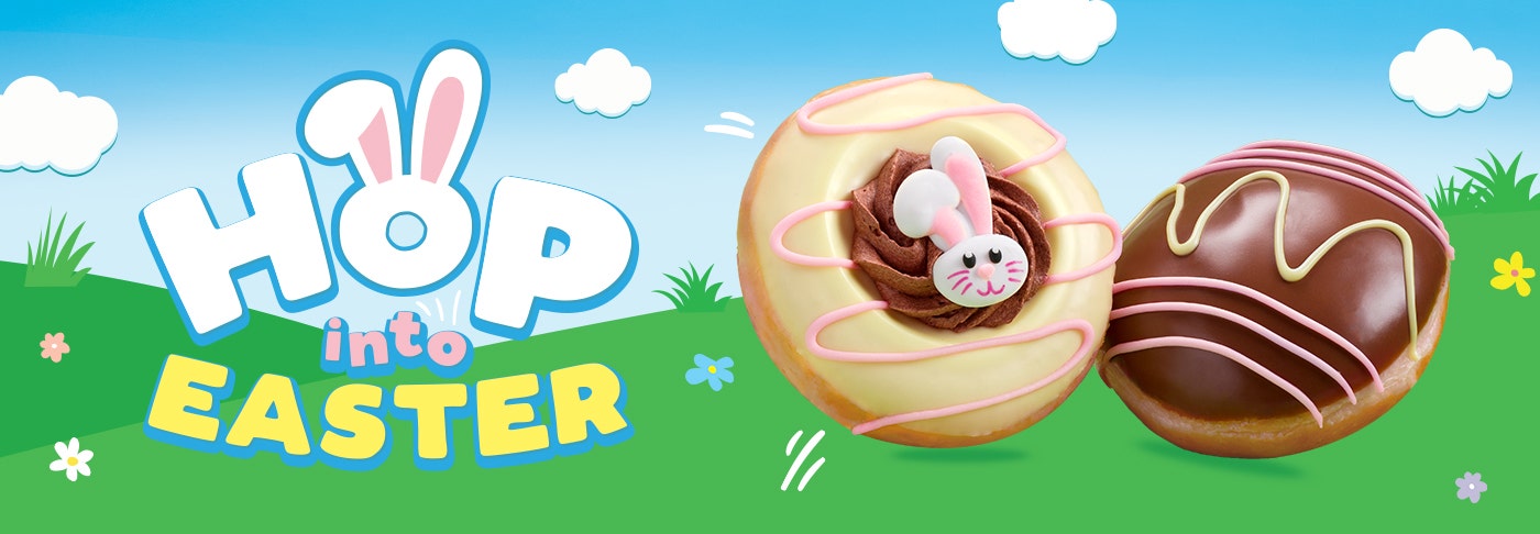 Hop into Easter with Krispy Kreme! graphic of two green hills with flowers and a blue, cloud-filled sky background with a title that reads: Hop into Easter. The Easter Bunny Doughnut and the Choc Caramel Easter Egg Doughnut are also featured on the right hand side of the banner