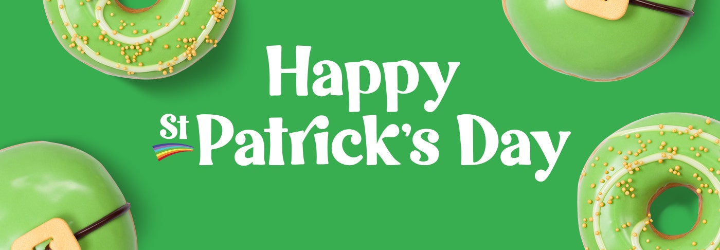 Banner featuring the words Happy St Patrick's Dayu in white text on a green background. Surrounded by green iced doughnuts, one with a belt buckle decoration, the other with a white spiral and gold sprinkles