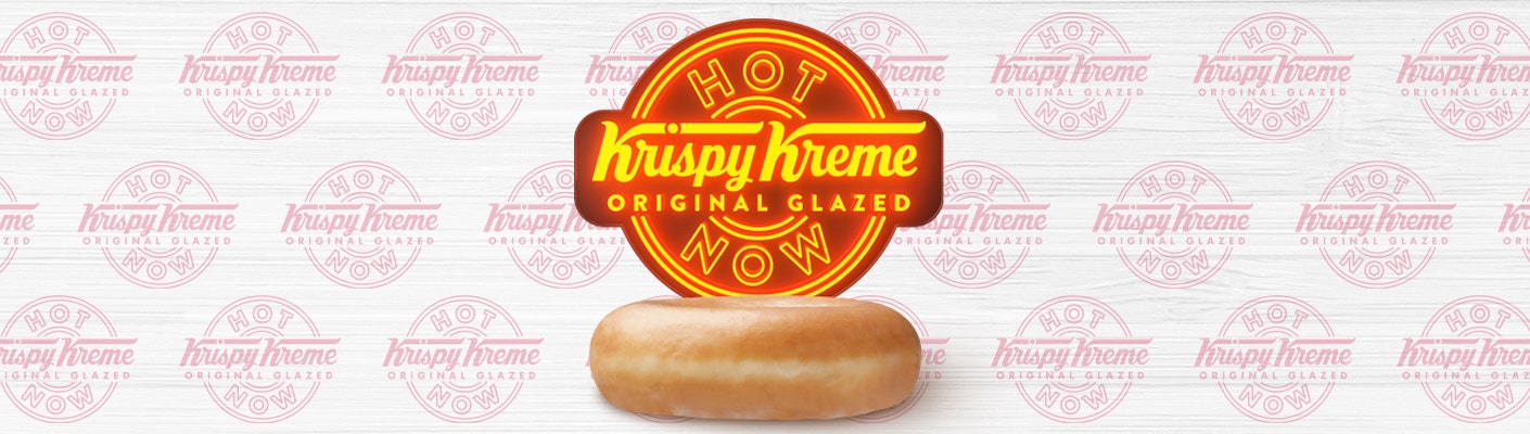 Krispy Kreme Original Glazed® Doughnut - Our History Krispy Kreme logo in neon effect above a glazed doughnut on a patterned background with repeated logos